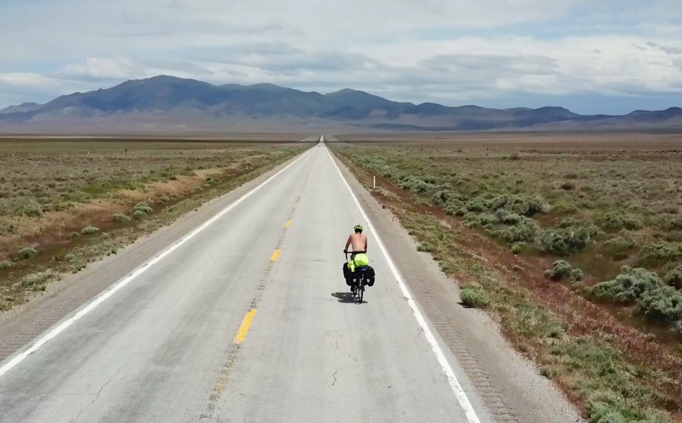 a cyclist from above on a wide road 